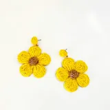 Aros colgantes con forma de flor, hechos con rafia color beige y centro amarillo.