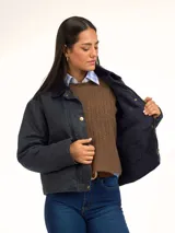 Campera de algodón encerado color bordó, con cuello de pana al tono, cierre frontal con botones a presión metálicos y bolsillos frontales con solapa.