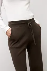 Pantalón tejido marrón oscuro de corte recto, con cintura elástica y cordón ajustable.