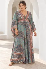 Vestido largo de estilo bohemio, color azul con estampado floral en tonos blancos y detalles geométricos en el escote y la cintura. Posee escote en V con cordones ajustables, mangas amplias tipo kimono y una silueta fluida y holgada.