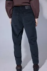 Pantalón de corte recto y tiro medio, confeccionado en tejido con patrón de cuadros oscuros. Presenta bolsillos frontales amplios y terminación con dobladillo en los tobillos.