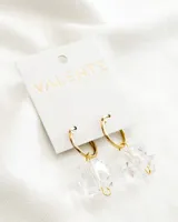 Aros colgantes con aro dorado y dije de cubo de cristal transparente. El aro es de acero.