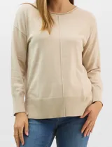 Buzo de tejido fino color amarillo, con cuello redondo, manga larga con puños acanalados y pespunte central vertical en el frente y la espalda. Presenta un ruedo ancho acanalado con tajos laterales.