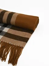 Bufanda tipo pashmina de tejido suave, color gris con diseño de cuadros en tonos oscuros y líneas finas en rosa. Presenta terminaciones con flecos en los extremos.