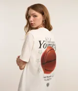 Remera blanca de algodón, de manga corta y cuello redondo, con estampa en la espalda de una pelota de baloncesto y texto.