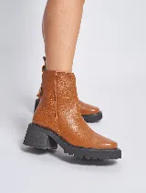Bota corta de cuero color marrón con suela track y cierre lateral.