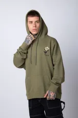 Buzo tipo canguro de corte oversize, color blanco, con capucha y cordones ajustables. Presenta un pequeño estampado de una rosa roja en el pecho y un bolsillo frontal tipo canguro.