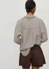 Short de algodón estilo denim, color marrón, con tiro medio, pinzas delanteras, cuatro bolsillos y bajo deshilachado.