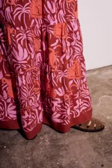 Falda larga de viscosa con estampado de animales y plantas en tonos marrón, naranja y rosa. Tiene cintura elástica rosa.