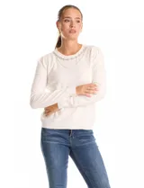 Buzo de tejido fino color blanco, con escote a la base decorado con un collar fijo de perlas y strass. Presenta mangas largas con un leve frunce en los hombros y puños tejidos.