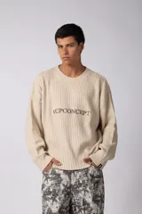 Sweater de punto acanalado en color beige, con cuello redondo y diseño de calce relajado. Presenta el logo VCPCONCEPT bordado en el centro del pecho y un pequeño parche distintivo en el puño de la manga.