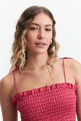 Blusa de algodón a cuadros color celeste y rosado, con escote recto, breteles finos y fruncido en el cuerpo.