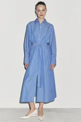 Vestido midi de corte camisero con estampado de rayas verticales, cuello solapa, manga larga con puños y cierre frontal con botones. Incluye un cinturón de lazada en el mismo tejido y bolsillos laterales ocultos.