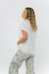 Camisa amplia de manga corta color amarillo, con cuello clásico y botones al frente.