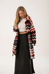 Tapado largo de lana con estampado zigzag horizontal en tonos rojo, negro, blanco y gris. De manga larga y abotonado.