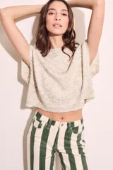 Chaleco de punto color crema con detalles en rosa y celeste, de corte holgado y mangas cortas.