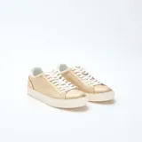 Zapatillas bajas de mujer, color dorado brillante, con cordones blancos y suela gruesa de goma blanca.
