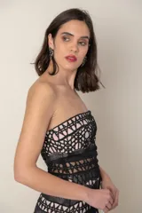 Vestido largo de fiesta negro con forro color nude y encaje calado con motivos geométricos. Diseño strapless con transparencia en cintura y ruedo.