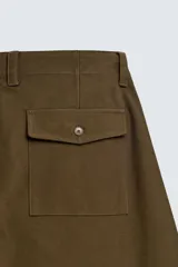 Pantalón de corte balloon fit, color negro, con bolsillos laterales de vivo y bolsillos traseros con solapa. Presenta cierre frontal con cremallera y botón.