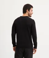 Suéter negro de tejido de punto pesado, con cuello redondo y mangas largas.