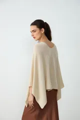 Poncho corto de tejido liviano en color crudo, con escote en V y diseño amplio y fluido.