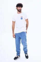 Remera de cuello redondo y manga corta, color blanco, con estampa circular pequeña en el pecho que incluye formas geométricas y texto.