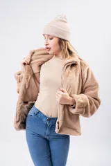 Campera de piel sintética negra con textura suave, cuello alto, cierre frontal y diseño holgado.