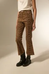 Pantalon jean de tiro alto con corte flare y ruedo desflecado, estampado con diseño animal print de leopardo en tonos marrones.