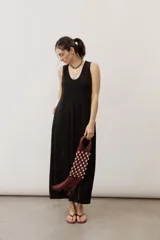 Vestido largo negro de corte holgado, sin mangas, con escote en V y bolsillos laterales.