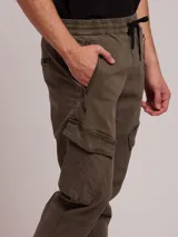 Pantalon cargo de sarga con cintura elástica y cordón de ajuste. Presenta bolsillos laterales tipo cargo con solapa y bolsillos frontales con cierre. Diseño con puños elásticos en los tobillos.