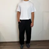 Pantalón sastrero color beige, de corte baggy, con pliegues en la cintura y bolsillos laterales.