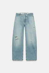 Jeans de mezclilla de tiro medio, corte wide leg y diseño relaxed. Presenta detalles rotos y desgastados en las piernas, y una cinturilla doblada superpuesta con trabillas y cierre frontal con cremallera y botón metálico.