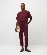 Pantalón fluido Cortelle de corte recto y estilo pijama, color bordó, con cintura elástica, cordón ajustable con punteras metálicas, bolsillos laterales y botamanga al tobillo.