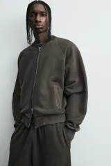 Chaqueta tipo bomber de corte relajado, confeccionada en tejido de mezcla de algodón con interior perchado. Presenta cuello subido, cierre frontal con cremallera, bolsillos de vivo en la cadera y acabados en rib en puños y bajo. Posee un acabado con efecto lavado.