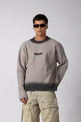Sweater de punto acanalado en tono gris claro, con efecto degradado oscuro en el cuello y el ruedo. Presenta un diseño de corte regular con cuello redondo y un pequeño logo bordado en el centro del pecho.