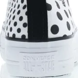 Championes Converse Chuck Taylor All Star Lift de plataforma, con diseño de lunares negros sobre fondo blanco. Presenta cordones blancos, puntera de goma y suela de plataforma elevada.