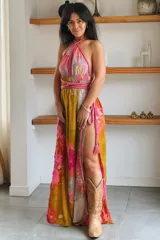 Vestido largo de seda con estampado abstracto en tonos marrones, beige y destellos dorados, con escote en V profundo, tirantes de cuerda anudados al cuello y la cintura, y tajo lateral en la falda.