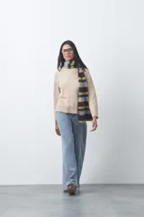 Polera de tejido liviano color negro con cuello alto y silueta relajada. Presenta mangas largas con puños ajustados y recortes laterales que aportan estructura al diseño.