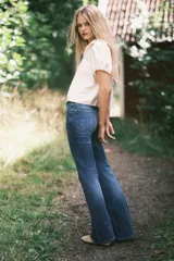 Blusa de viscosa con acabado satinado, cuello Peter Pan fruncido con detalle de encaje, frente abierto con cierre de triple tira y mangas cortas abullonadas con puños elásticos.