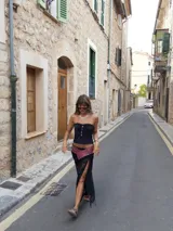 Faja ancha de cuero marrón con diseño cruzado, decorada con tachas metálicas en todo su contorno y cierre mediante hebilla de argolla metálica.