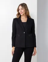 Blazer entallado marca Nanette, color negro, con cuello de solapa y cierre frontal de un solo botón. Cuenta con bolsillos delanteros y forro interno a tono.