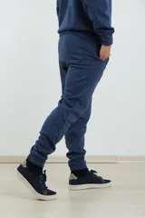 Pantalón jogging de corte ajustado, con cintura elástica y puños elastizados en los tobillos. Presenta un diseño minimalista en color gris oscuro, ideal para un look urbano y deportivo.