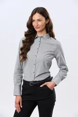 Camisa rayada de manga larga con cuello camisero, cierre frontal de botones y corte clásico al cuerpo.