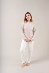 Pijama de dos piezas con estampado floral en tonos rosados y celestes sobre fondo blanco. La camisa es de manga larga con cuello mao y cierre frontal con botones. El pantalón es largo y de corte recto.