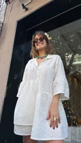 Vestido corto blanco con bordado calado, corte holgado, cuello camisero y mangas 3/4 con volados.