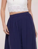Falda larga de color blanco con pretina elastizada y fruncidos en la cintura, con caída holgada y ligera.