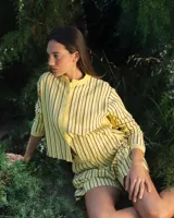 Cardigan tejido con lurex y botones en la delantera, color amarillo con rayas horizontales marrones.