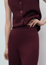 Pantalón de punto fino color bordó, de tiro medio y diseño largo con corte recto y cintura con goma elástica.