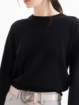 Sweater de punto negro ultrasuave, con cuello redondo, hombros caídos y mangas largas de corte holgado.