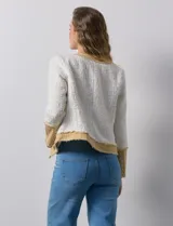 Chaqueta Nanette de tejido tweed y denim color blanco con cuello a la base y abertura central. Delantera con bolsillos, puño con aplique de botones metálicos y terminación desflecada.
